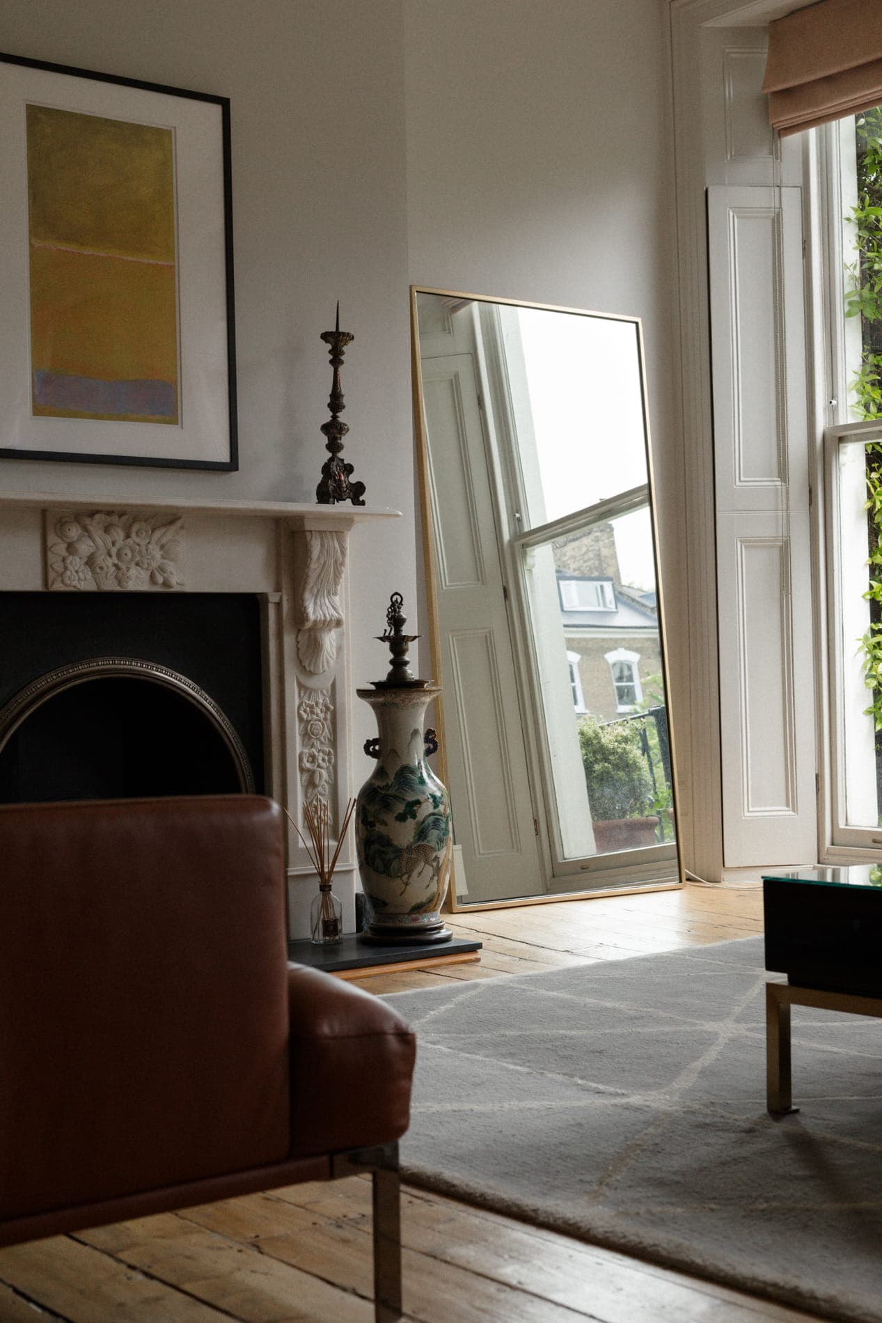 Editorial London townhouse drawing room — marble fireplace, full-length mirror, natural light through tall windows